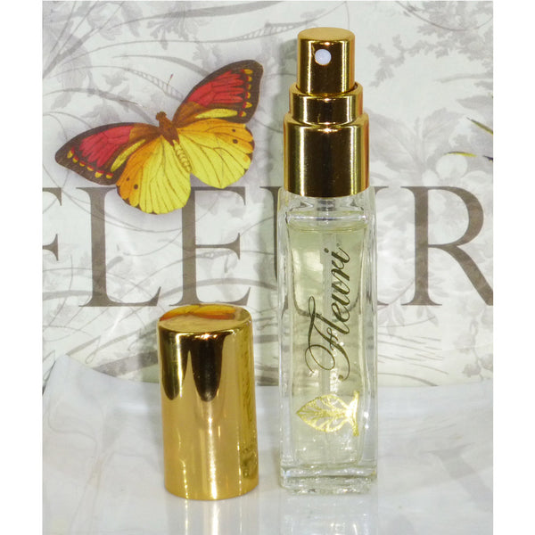 Fleuri Perfume bottle with the gold lid off and a gold spray. 