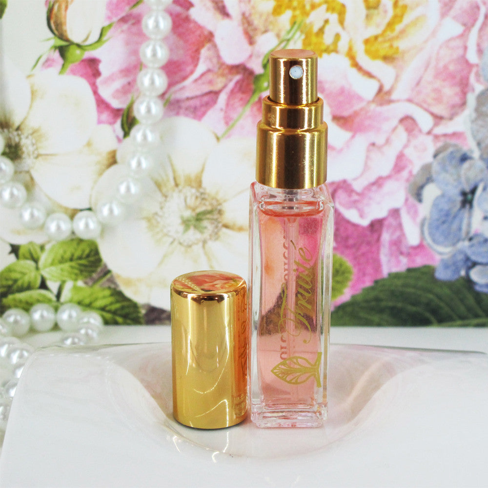 Fruité Fragrance with a gold top sitting next to the opened bottle.
